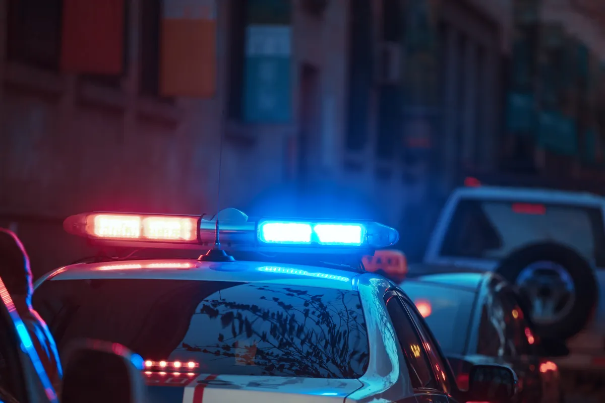 Luces de un patrullero policial durante la noche, referencia a una detención o investigación penal